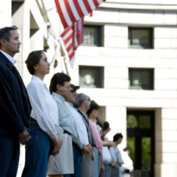 A group of people standing in a line outside a government building with the American flag in the background.