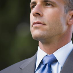 A portrait of a middle-aged man looking off into the distance, wearing a suit and tie.