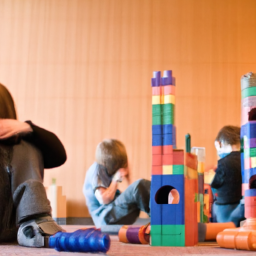 description: an anonymous image showing a young child playing with building blocks, engrossed in their own world, while other children interact and play together nearby.