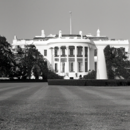 description: a black and white photograph of the white house, viewed from the front lawn with a clear blue sky in the background.
